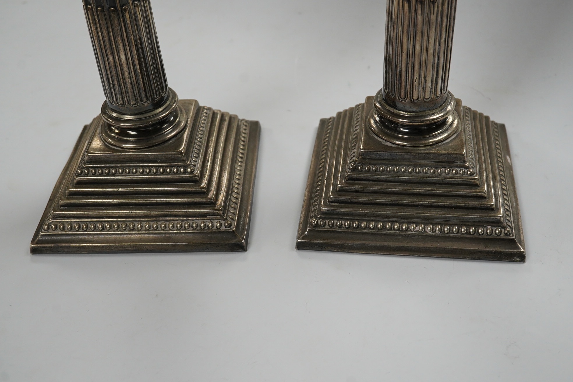 A pair of Elizabeth II silver Corinthian column candlesticks, Alexander Smith, Birmingham, 1972, sconces unmarked, 25.7cm, weighted. Condition - fair